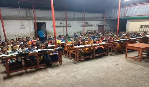 Children studying at desks in the orphanage hall