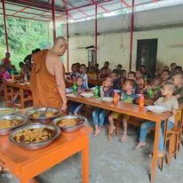 A monk serving a meal to the children