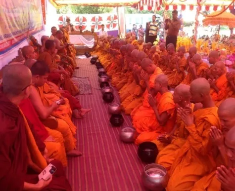 Rows of monks in saffron robes at a ceremony