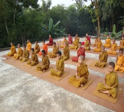 Novices in meditation, seated on mats in neat rows