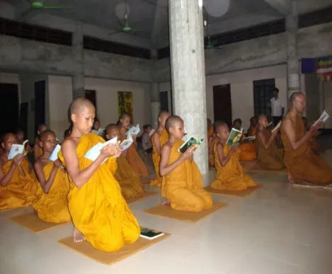 Young novices kneeling as they read their texts
