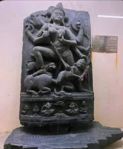 Black stone stele carved with a multi-armed deity