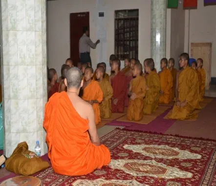 A senior monk leading a session for novices